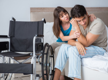 woman consoling young man in wheelchair